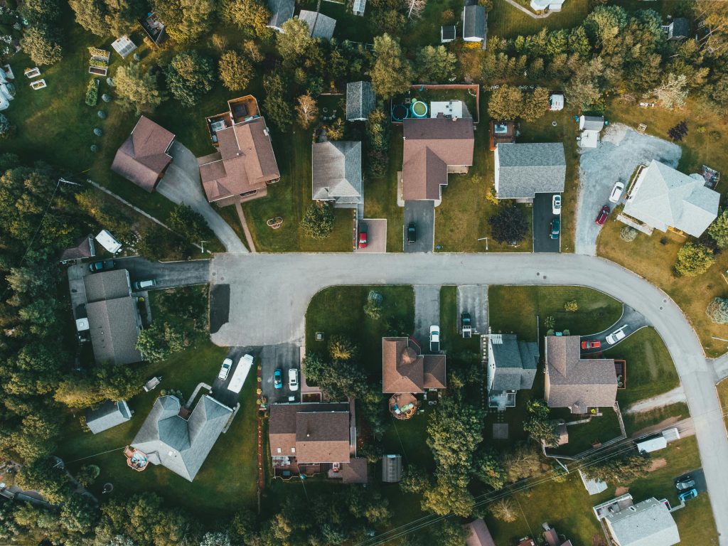 A top-down view of a suburban neighborhood showing houses, streets, and greenery.
